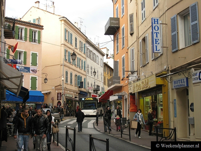 De Rue du Maréchal Joffre ligt maar een paar honderd meter van de jachthaven in het centrum van Cannes. Bij het gebouw met de groene luiken begint de winkelstraat Rue Meynadier. Foto's van de winkelstraten van Cannes.
