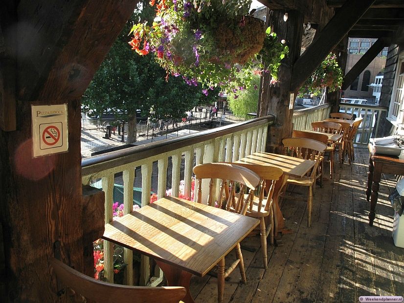 Op de balkons van de Dickens Inn kun je met een fantastisch uitzicht pizza eten.