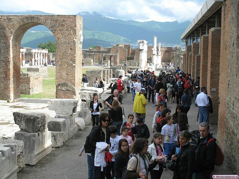 De Agora of marktplein van Pompeii. Het kan hier nogal druk zijn. Rechts is de opslag van opgegraven objecten. Hier zijn ook afgietsels van enkele slachtoffers van de ramp te zien.
