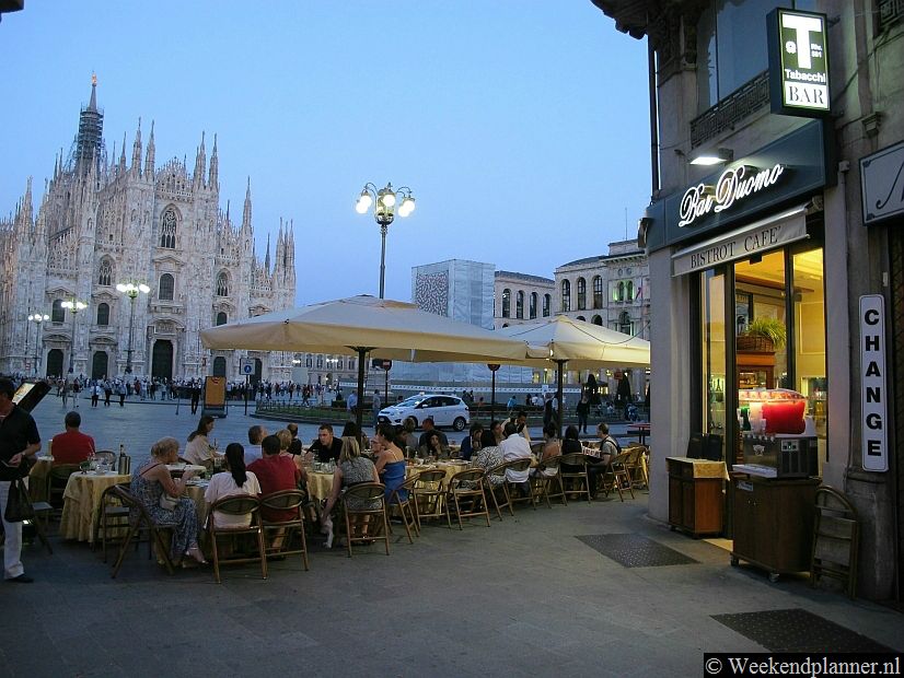 Tegen de avond is er in de winkelstraat Via de Mercanti dit terras. Op de achtergrond zie je de Duomo.Tips: De  restaurants en cafés van Milaan.
