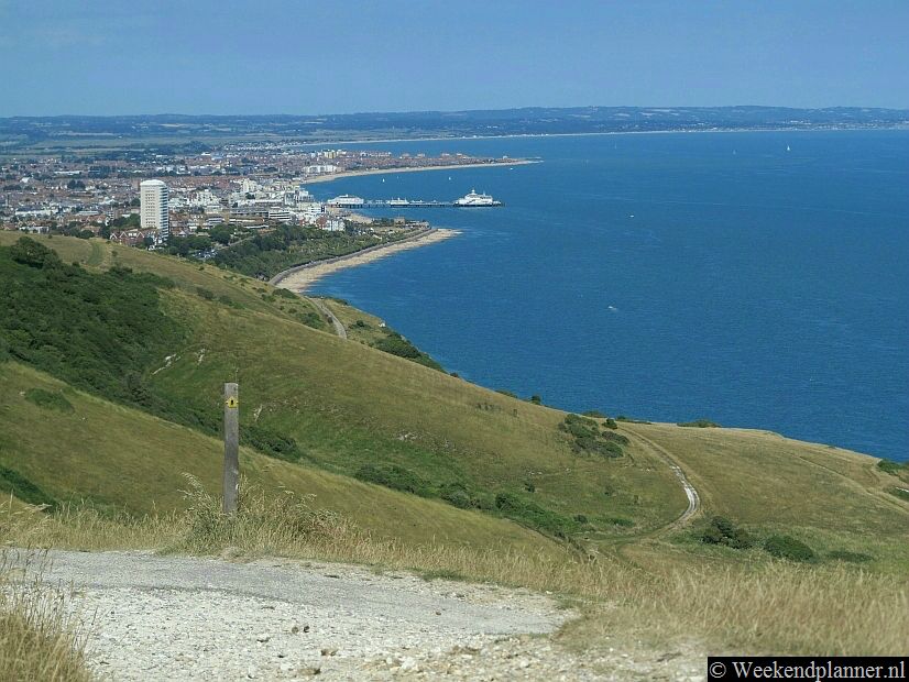 Eastbourne gezien vanaf de krijtrotsen van Beachy Head. Je ziet op de foto de promenade,  de stranden en de pier.Tip: De witte klippen van Beachy Head.
