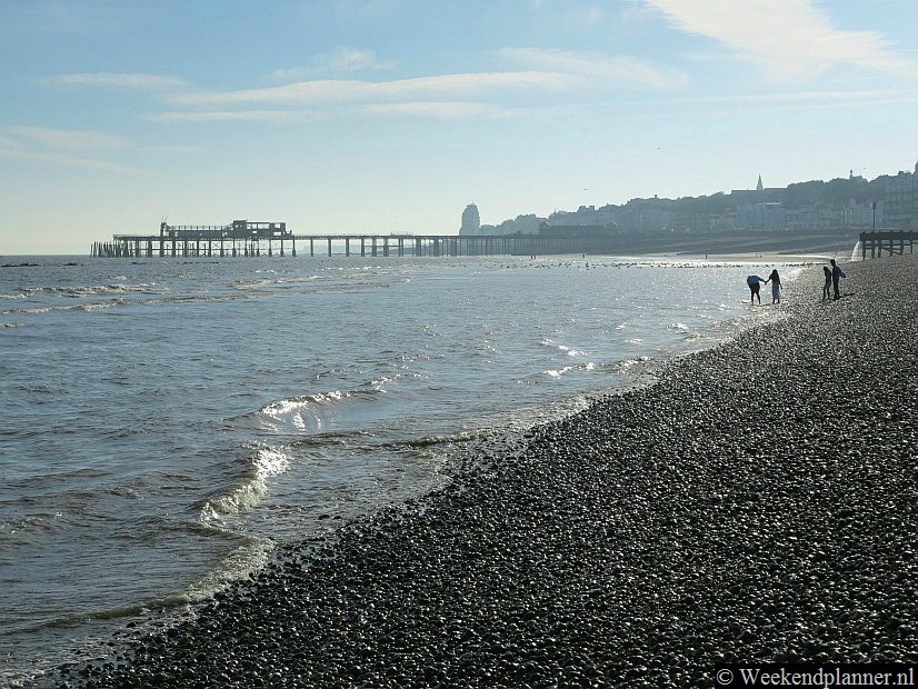 De 19de-eeuwse pier van Hastings was van hout en brandde in 2010 af. Op de foto zie je het geraamte van de pier vanaf het strand. Inmiddels is de pier herbouwd en je kunt er weer op. Tip: Een weekend in Hastings.