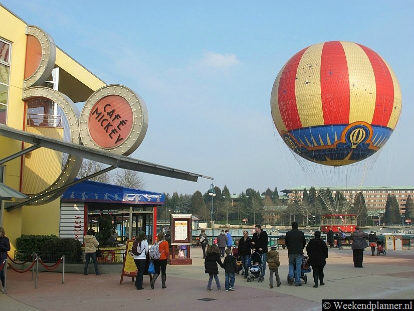 In Café Mickey kun je Disneyfiguren tegenkomen. Daarachter zie je de luchtballon PanoraMagique. Voor een paar tientjes kun je opstijgen en dalen. De luchtballon zit wel vast aan een touw.